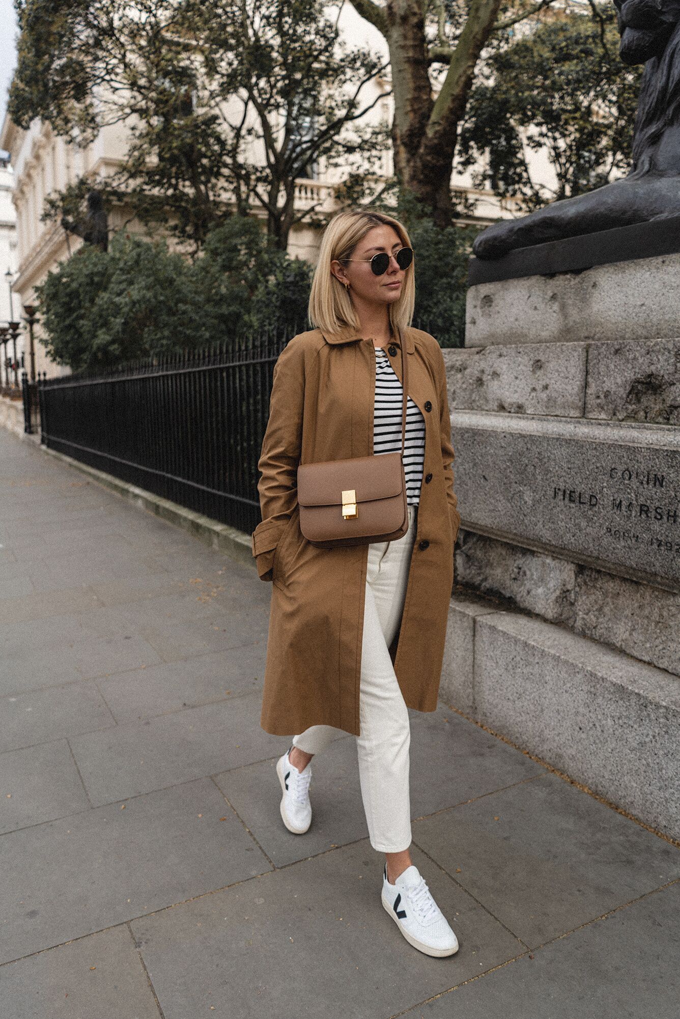 Emma Hill style, tan mac coat, stripe t shirt, white jeans, Veja V-10 trainers, Celine Box Bag, chic Spring outfit Source: https://emmajhill.com/im-back/